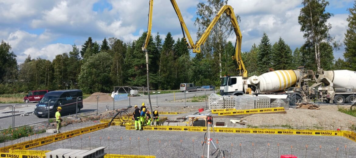 Tredun asuntomessutalon rakennustyömaa ja anturoiden valutöitä, taka-alalla sementtirekka