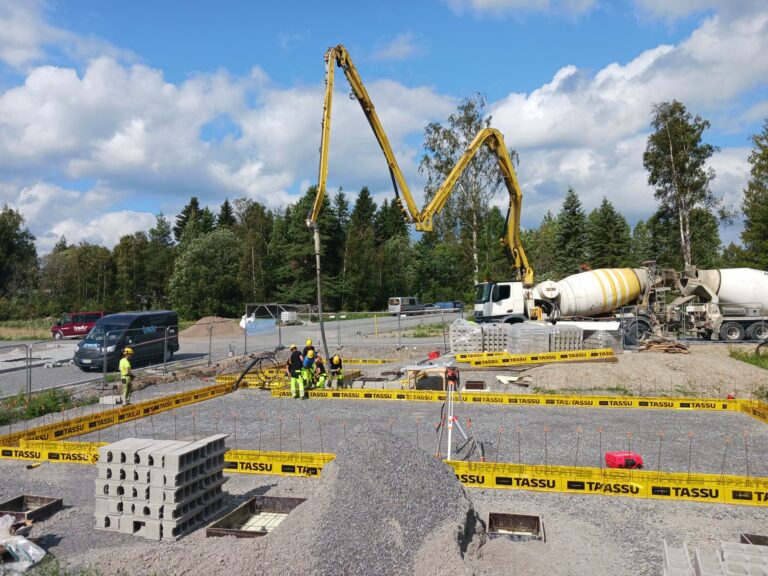 Tredun asuntomessutalon rakennustyömaa ja anturoiden valutöitä, taka-alalla sementtirekka